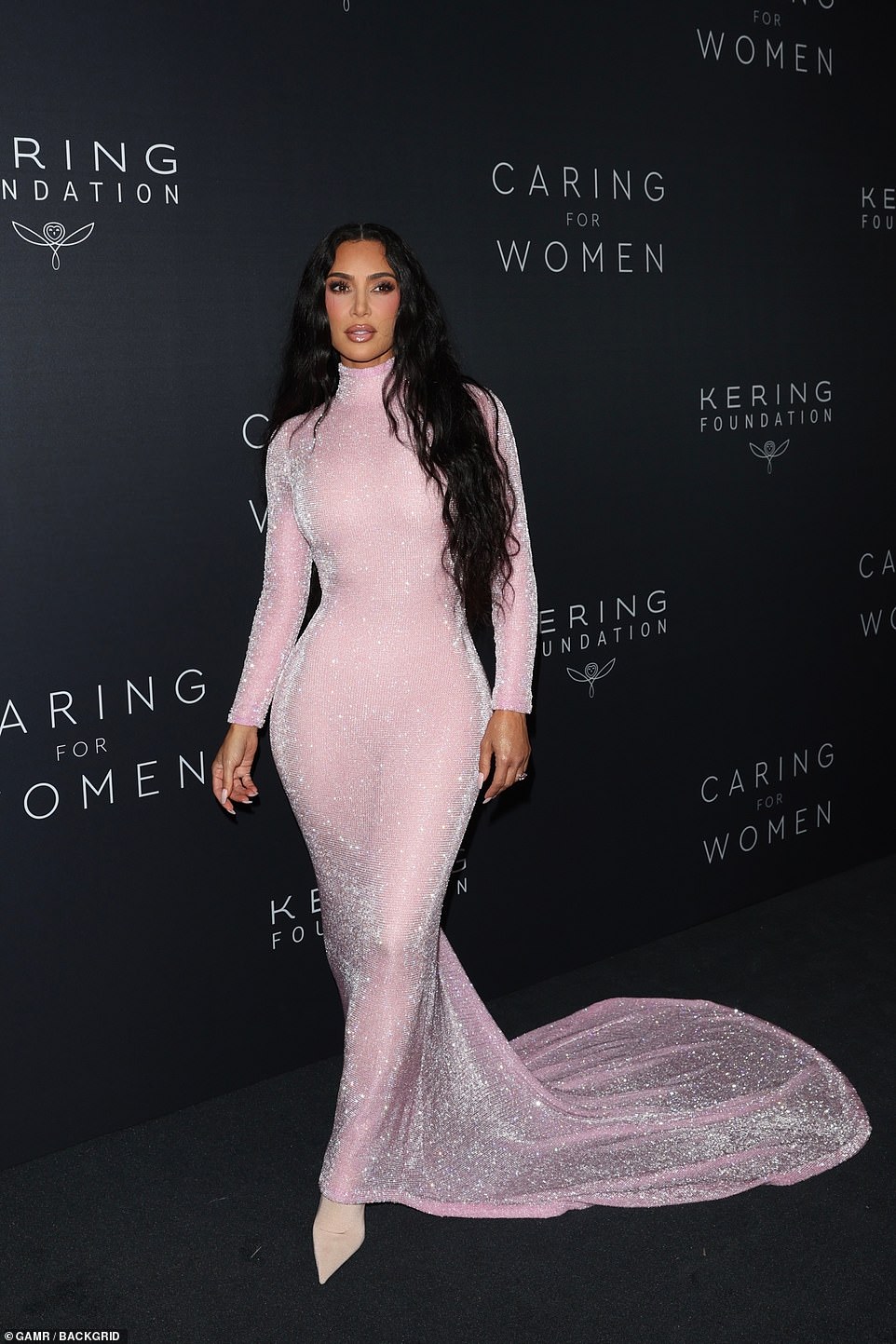 Dazzling: The 41-year-old SKIMS founder dazzled under the lights as she posed for shutterbugs in a figure-hugging baby pink Balenciaga dress adorned with crystals