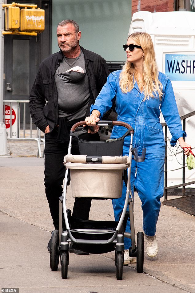 Family outing: Liev Schreiber was every bit the doting new dad as he carried his daughter Hazel in a sling while walking with wife Taylor Neisen in New York on Wednesday