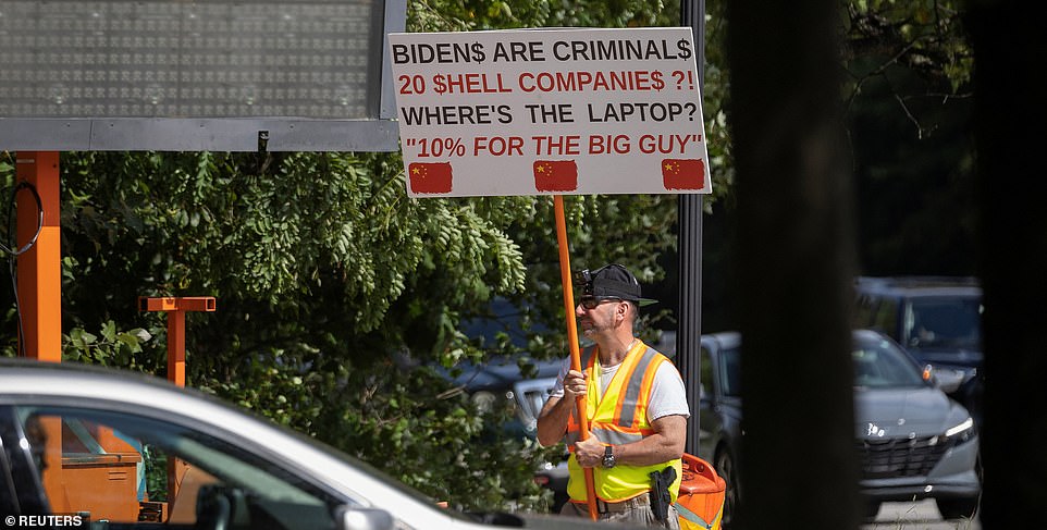 On Sunday, a man with a gun was seen protesting near President Joe Biden's home in Wilmington, Delaware.  The man, wearing a yellow-and-orange safety vest, carried a sign that read: “Bidens are criminals, 20 shell companies?!  Where's the laptop?  10 percent for the big man.”  The other side of his sign said, “Joe has aliases?!  Robert L. Peters, Robin Ware, JRN Ware.'