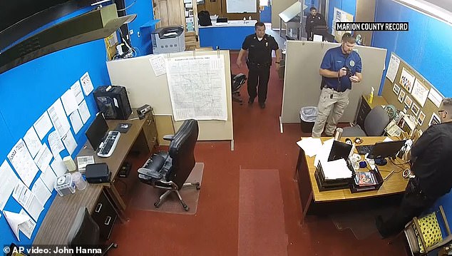 The raid, conducted on August 11, was personally led by Marion Police Chief Gideon Cody (center).  He was only sworn in in May and faces charges that he violated a reporter's constitutional rights by confiscating her phone during the raid — a move the newspaper's publisher says was prompted by the woman's investigation into his background at another police station.