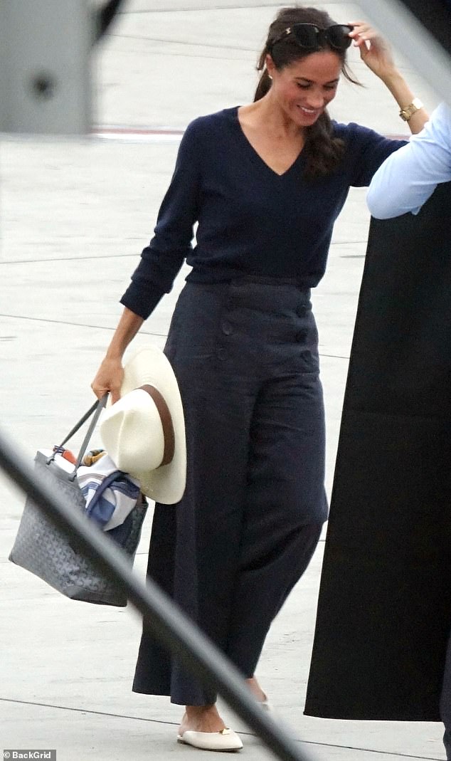 Let's fly!  Meghan Markle wore a casual couture ensemble when she arrived at LAX on Monday evening, including $770 Valentino mules in ivory and a $2,650 Goyard tote