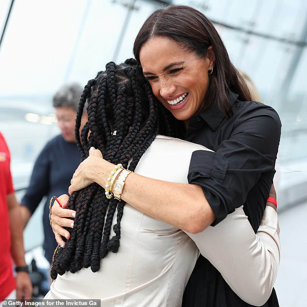 Meghan Markle is pictured hugging Glory Essien as she meets competitors, friends and families in Dusseldorf during the Invictus Games