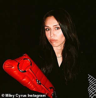 The 30-year-old singer showed off her new dark hair as she posed in a black blazer with a bright red bag