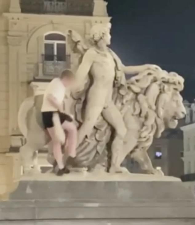 Shocking video of Sunday's incident shows the man, who appears to be drunk, climbing the statue