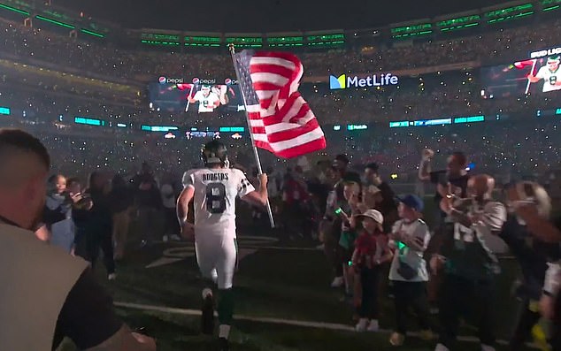 Aaron Rodgers ran onto the field before the game with an American flag in his hand