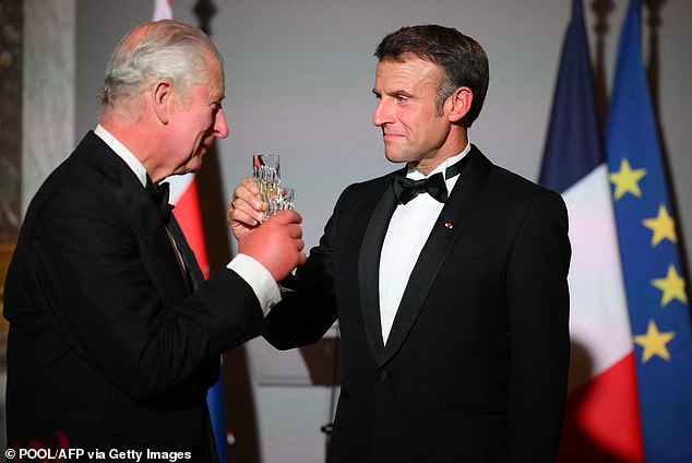 French President Emmanuel Macron (R) toasts with British King Charles III (L) during a state banquet at the Palace of Versailles, west of Paris, on September 20, 2023