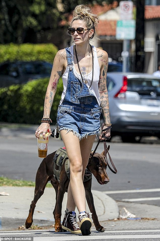 Enhanced security: Paris Jackson, 25, headed out with a Doberman Pinscher and a security guard followed close behind her after the latest report of a man stalking her