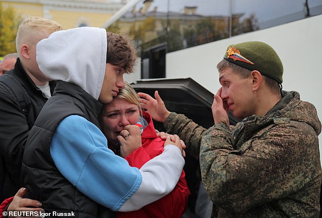 A Russian reservist says goodbye to family members before leaving for a base for partial mobilization of troops, in Gatchina, Russia, on October 1, 2022