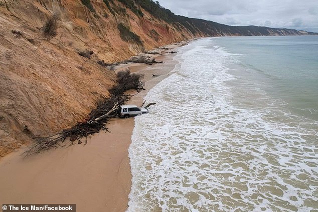 A 4x4 got stuck in the sand as it drove through waves at Rainbow Beach in Queensland during high tide.