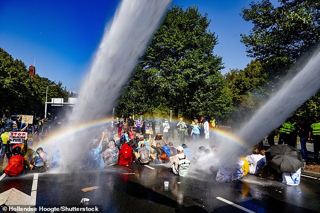 Environmental protesters were shot with water cannons on Friday as Dutch police tried to clear them from a major road in The Hague