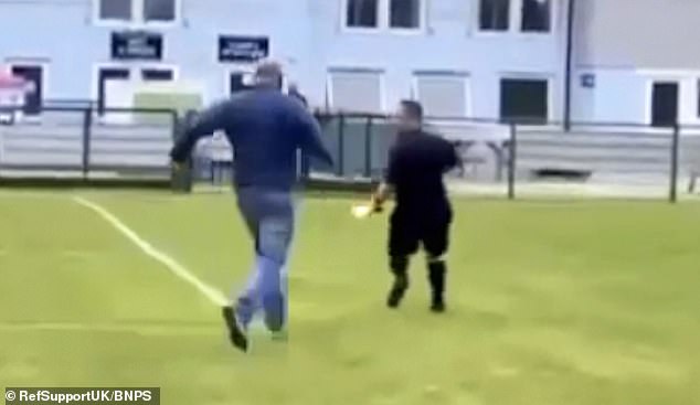 This is the moment a referee is chased off the pitch by an irate parent during an under-18s football match in Dorset