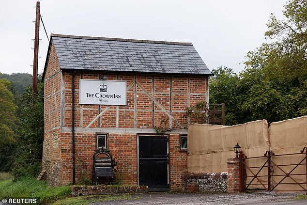 Locals claim the hessian-lined barriers were put in place around the Grade II listed pub this morning, with three security guards outside and as many as six men inside