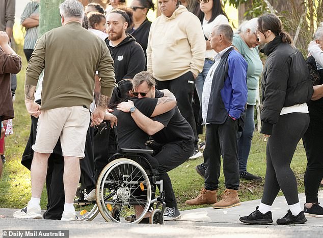 Mourners hugged after a ceremony honoring the victims of the Russell Island fire