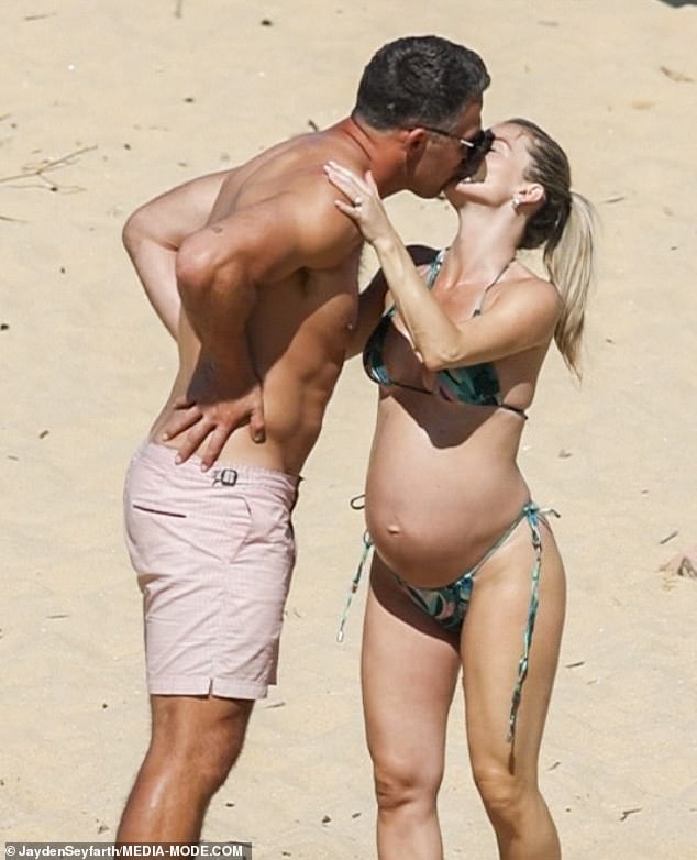 Sam Burgess, 34, and Lucy Graham, 33, are just weeks away from welcoming their first child together.  And the pair looked hotter than ever for each other on Tuesday as they soaked up the sun on the beach