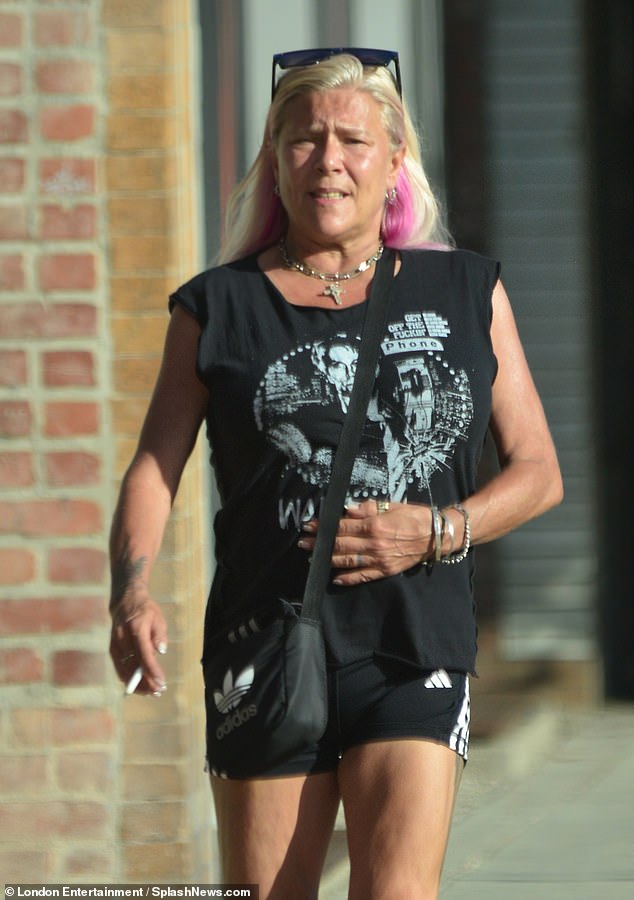 Outing: Sam Fox, 57, went makeup-free on Friday for a relaxing walk with wife Linda Olsen during their vacation to Los Angeles