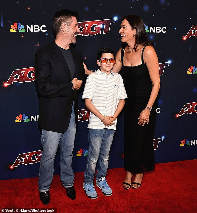 All smiles: Simon looked dapper in a gray T-shirt and faded jeans as he posed with Lauren and Eric, who wasted no time trying on his orange-tinted glasses