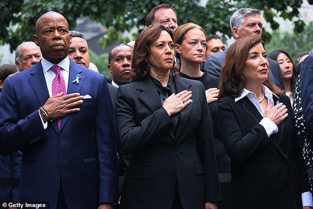 Vice President Kamala Harris places her hand on her heart during the national anthem at the 9/11 Memorial in New York City on Monday.  She stood next to Mayor Eric Adams (left) and New York Governor Kathy Hochul (right) during the service.