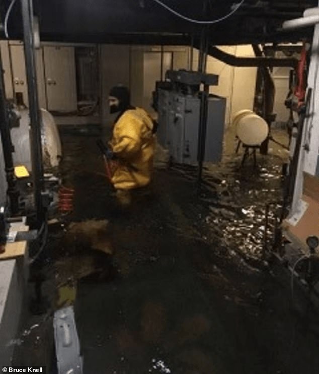 One of the squatters is seen in the boiler room of the motel, which was already flooded