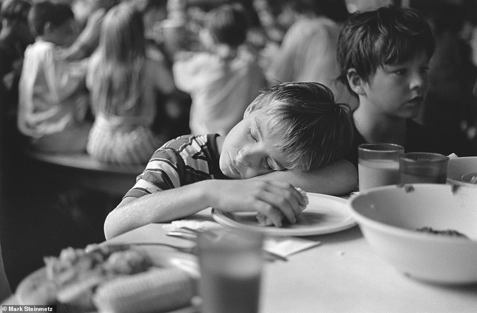 A youth takes a nap while eating his dinner.  Steinmetz says the photos are timeless.  Summer camps haven't changed that much, so many viewers can relate to them wherever or whenever they went to summer as youngsters.  'At summer camp you have sleeping bags and huts.  There's not much difference between them in 1990 and 1965,