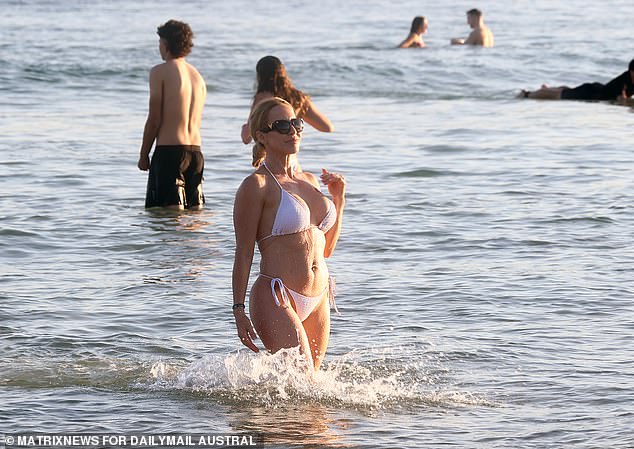 Although the water is cool, unusually warm weather drives thousands of people to the beach