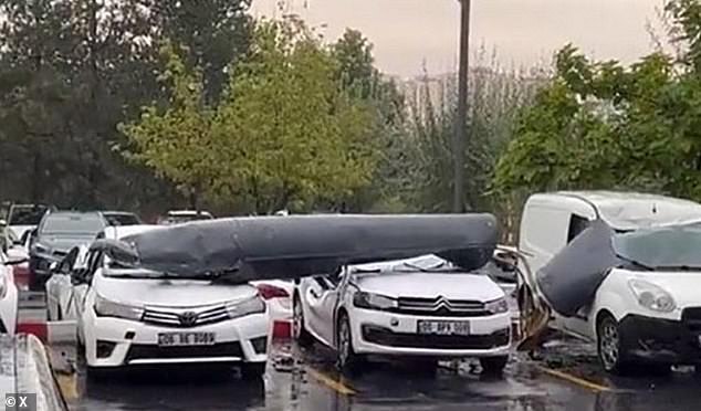 The aftermath, filmed by bystanders, shows the tank on top of the two cars, whose roofs, windows and parts of the doors were completely crushed by debris.  No injuries or deaths have been reported as a result of the crashed fuel tank