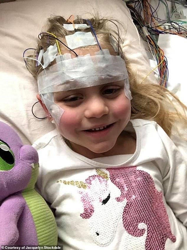 Isla is pictured above in hospital after undergoing a test.  She now takes an $18,000-a-month drug that her mother says has stopped the progression of the disease