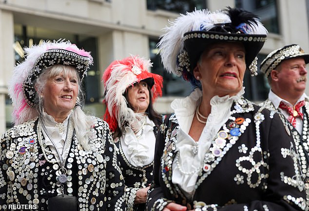 The famous Pearly Kings and Queens Society fundraisers came to London today in their glittering button-up outfits (pictured)