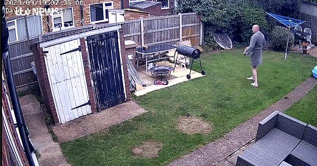 CCTV footage from the couple's home shows a wild fox hiding in the garden of Dave Masters, 55, and the garden of his wife Sarah, 48, before Dave, wearing a dressing gown, comes around the corner with their two dogs Benji and Mylo