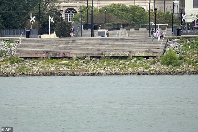 The low water level of the Mississippi River is seen as people sit on steps that normally flow into the river in the French Quarter of New Orleans, on September 25, 2023