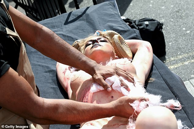 A topless PETA supporter has dressed up as a bloody goat outside a London Fashion Week venue to protest the use of cashmere in the fashion industry