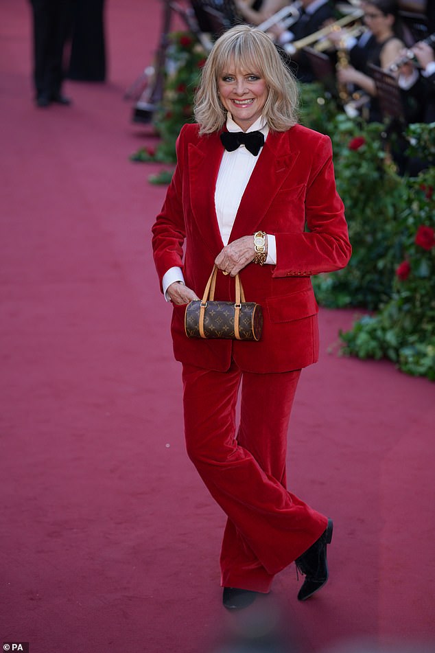 Icon: Twiggy stood out in a striking red velvet suit as she arrived at the Vogue World Show at the Theater Royal Drury Lane in London on Thursday evening