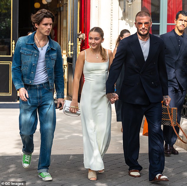 Brave: David Beckham wore a navy blue suit, layered over a plain white T-shirt and a pair of orange-toned shades