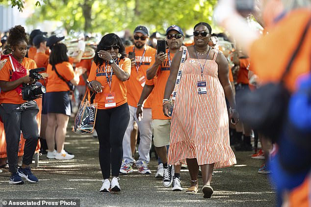 Family member of the shooting victim, Brenda Hollins, left, and Virginia staffer Ambria Thomas, walk toward Scott Stadium before Saturday's game