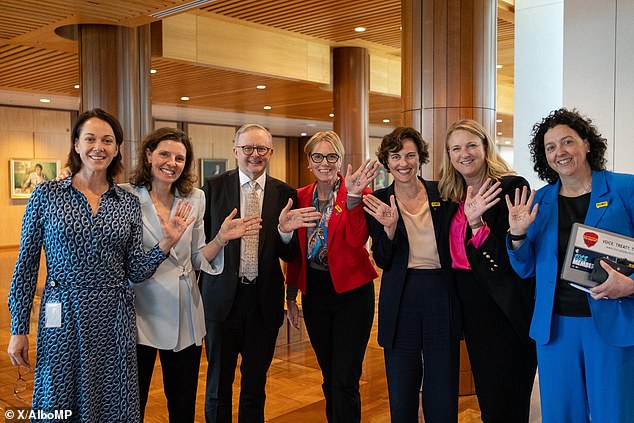 MPs from different benches (pictured from left to right) Sophie Scamps, Allegra Spender, Zoe Daniel, Kate Chaney, Kylea Tink and Monique Ryan posed for a photo with the Prime Minister with the word 'Yes' drawn on their hands