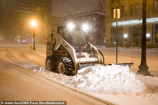 A skid steer plows snow in front of the Ohio Statehouse in Columbus, Ohio, as a major winter storm brought freezing temperatures to the state in December 2022