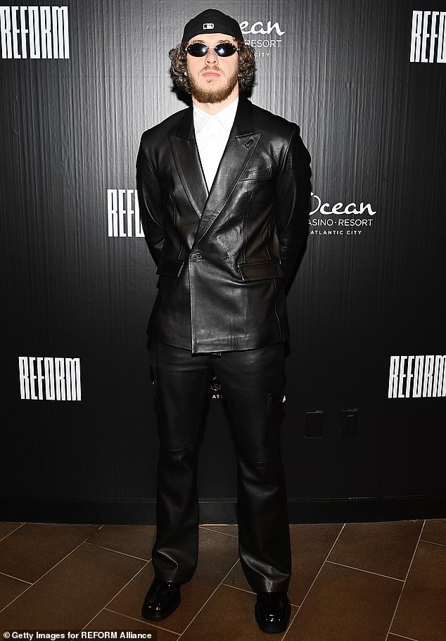 Notable: Rapper and actor Jack Harlow, 25, wearing a black leather suit with a double-breasted jacket and a white button-up shirt