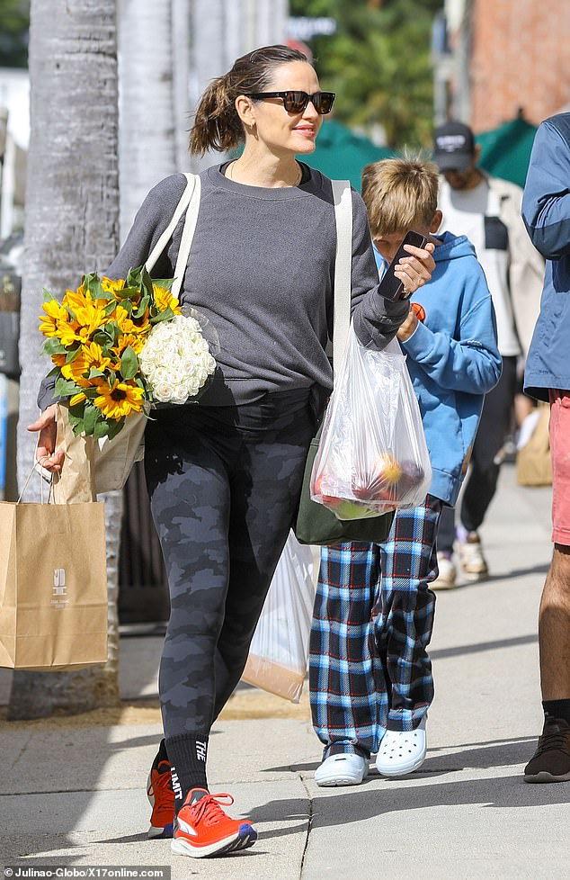 Ritual: The 51-year-old actress certainly had her hands full carrying two dozen white roses and brown-eyed Susans, as well as several bags filled with orange juice, peaches and apples