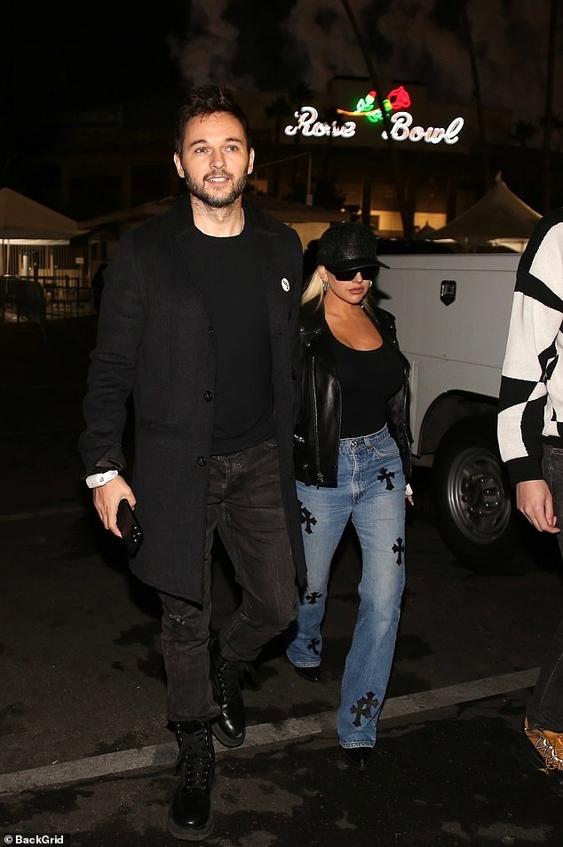 Christina Aguilera wore a stylish ensemble of a black leather jacket over a black top with blue jeans to the concert, alongside fiancé Matthew Rutler, 38