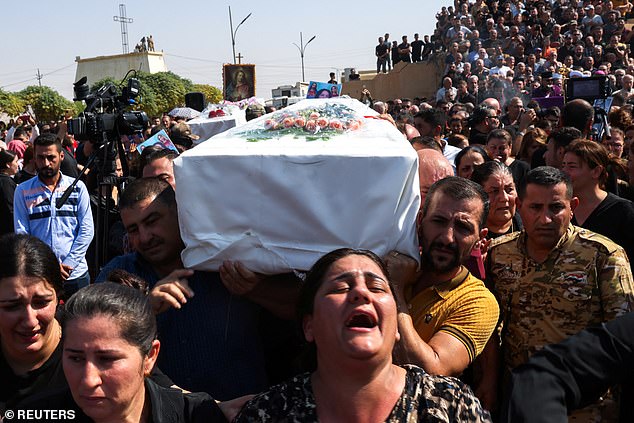 Mourners carry a coffin during the funeral of the victims of the fatal wedding fire in Hamdaniya, Iraq, on Thursday