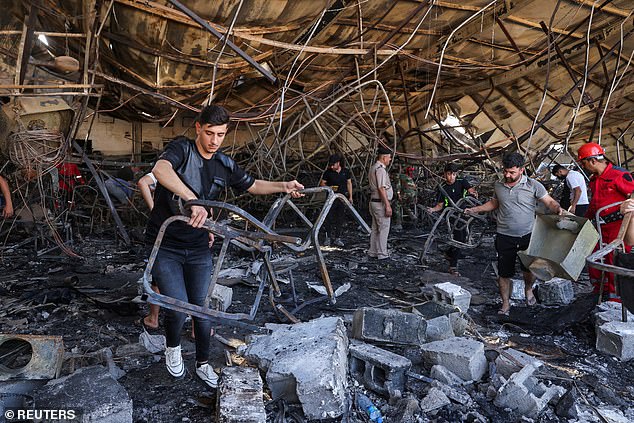 Volunteers search for the remains of missing bodies after a fatal fire at a wedding party in Iraq on Thursday