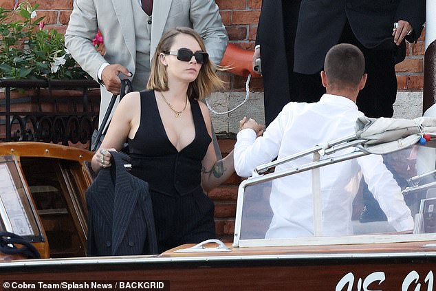 Stunning: Cara wore her short blonde locks down and pinned behind black hair clips as she was helped into a water taxi