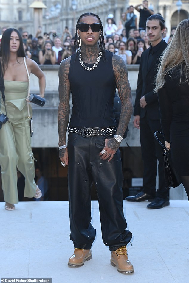 Getting involved: Rapper Tyga showed off his heavily tattooed arms, neck and chest in a black vest as he arrived before the event