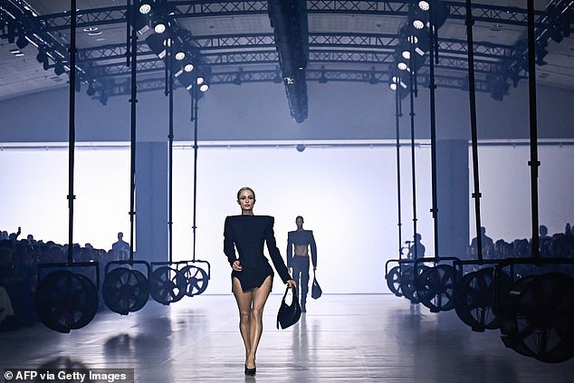 Step by step: Paris showed off her legs as she walked the brightly lit catwalk