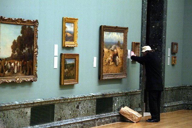 Pictured: an artist, probably Banksy, exhibiting his latest creation at the Tate Britain in 2003