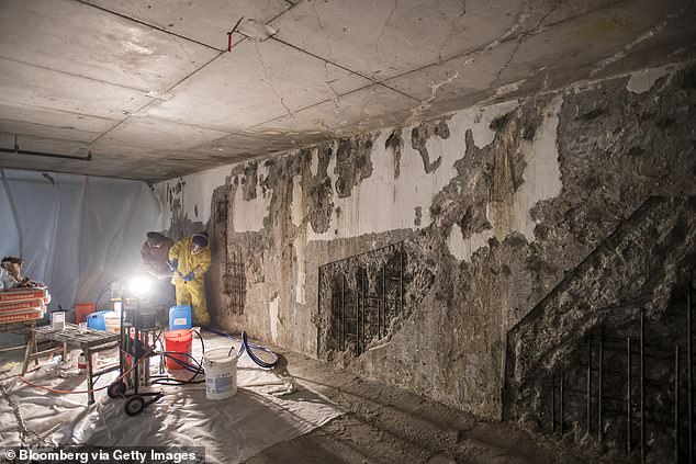 Workers repair crumbling walls caused by leaking water in the garage of San Francisco's Millennium Tower