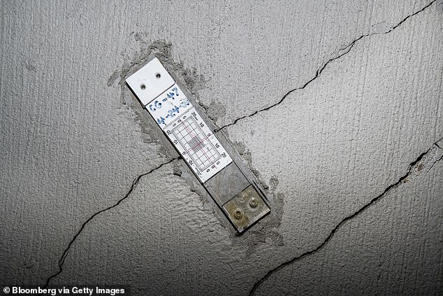 A strain gauge can be seen on a wall with floor-to-ceiling cracks in the Millennium Tower parking garage