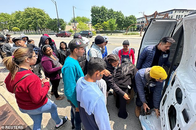 Migrants receive supplies outside the Chicago Police Department's District 12 station