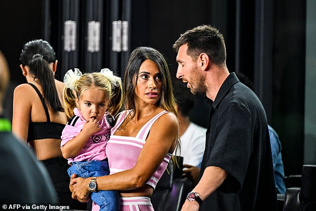 Messi stood next to the beautiful woman Antonela Roccuzzo, who held a young girl in her arms