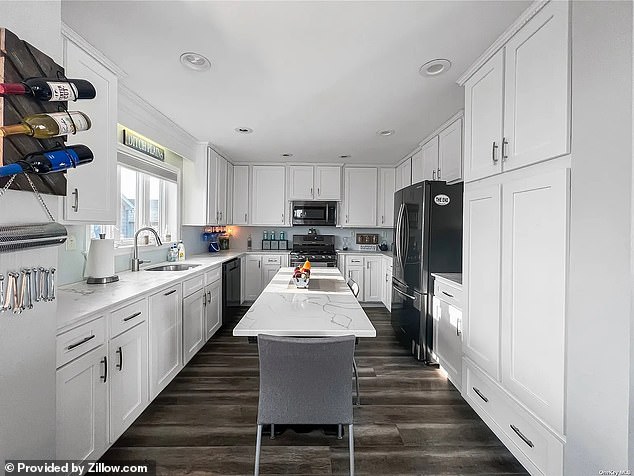 The house is furnished with white cabinets, making the kitchen look sleek