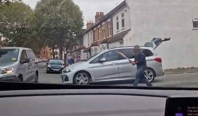 The man takes the sports equipment from the trunk of his car and starts walking towards the van